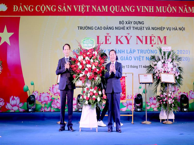 Thứ trưởng Bộ Lao động - Thương binh và Xã hội Lê Tấn Dũng tặng hoa chúc mừng cán bộ, giáo viên Trường Cao đẳng nghề Kỹ thuật và Nghiệp vụ Hà Nội